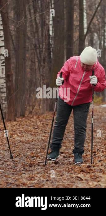 Two happy elderly women in autumn park doing warm up before exercises ...