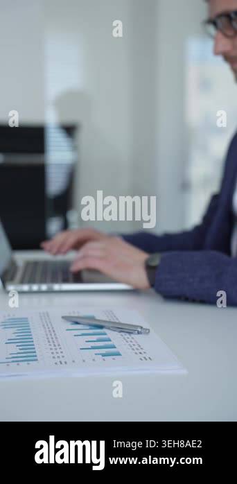 Businessman working on a laptop, typing at his desk with focus and ...