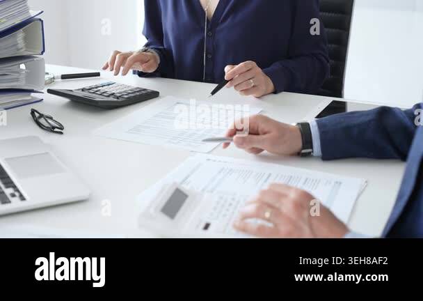 Female financial analysts examining documents, using magnifying glass ...