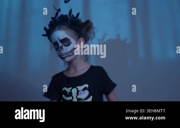 A young girl twirls in a mysterious forest, her face painted like a ...