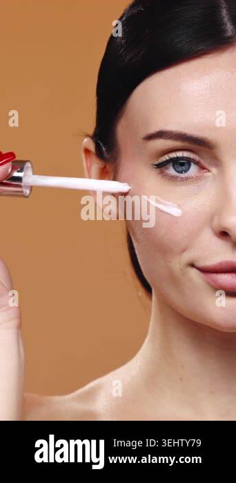 Picture of Woman applying skincare serum to her face with a dropper in a ...