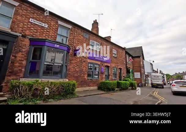 Brick buildings with purple signage along a quiet street surrounded by ...