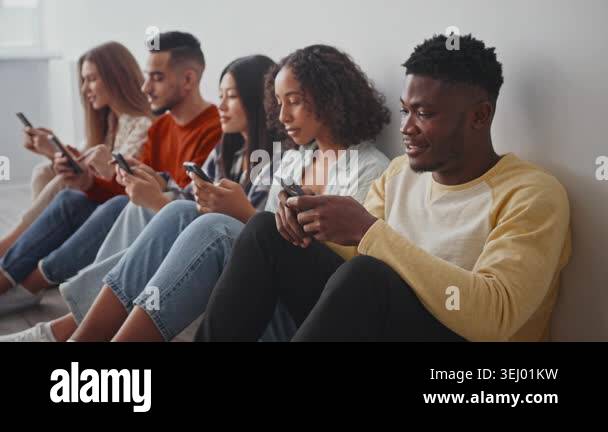Picture of Five individuals are engaged with their smartphones while seated on the ...