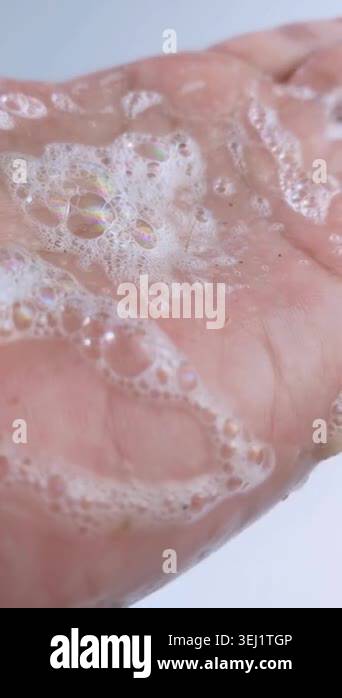 Showing soap foam bubbles on hand and rubbing palm gently. Close up ...