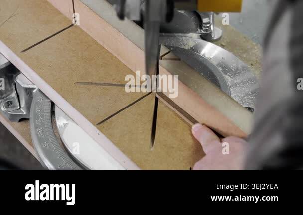 Worker cutting a wooden furniture panel with circular saw machine ...