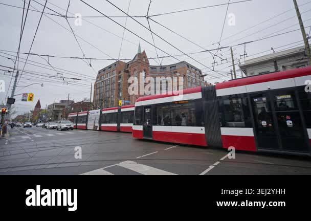 Toronto streetcar turning at urban intersection with city traffic and ...