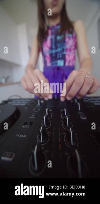 Female DJ tuning mixer knobs with precise hand movements, colorful top ...