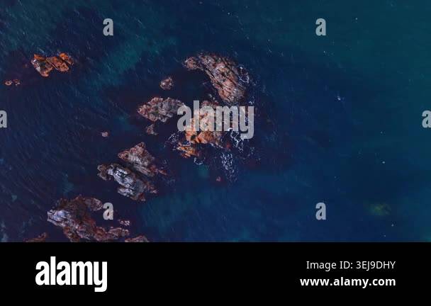 Top view of dark sea water with rocky formations. Aerial top-down view ...