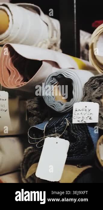 Vertical video. Textile material rolls and upholstery fabric stored in ...