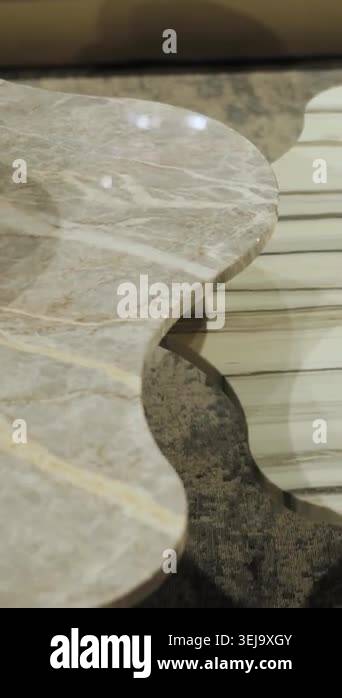 Vertical video. Close-up of white marble coffee tables with curved ...
