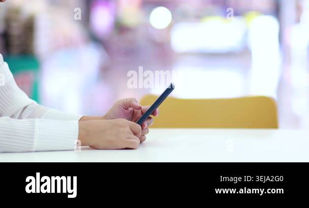 Hands using a smartphone at a table, representing communication ...