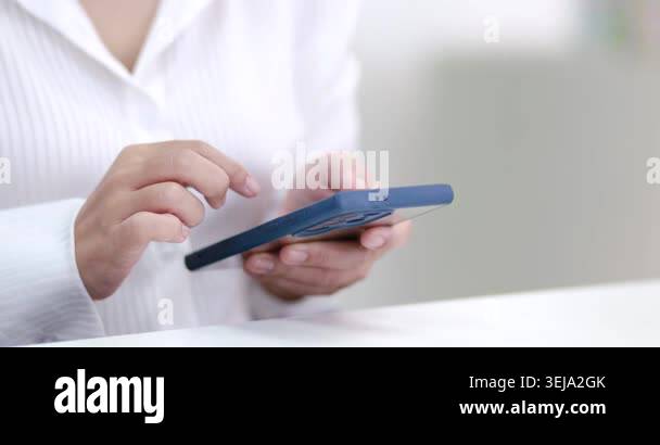 Hands using a smartphone at a table, representing communication ...