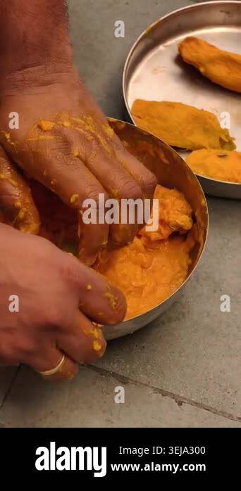 Pulp Hand Image Close-up of hands extracting fresh mango pulp for traditional Aamras ...
