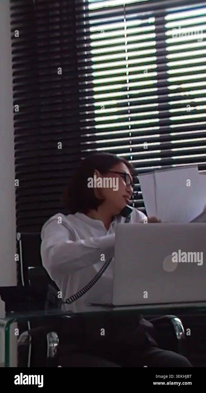 Professional woman multitasking at glass desk Stock Video Footage - Alamy