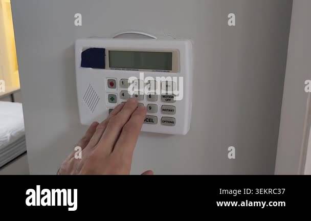Video footage of a person entering a security code on a wall mounted ...