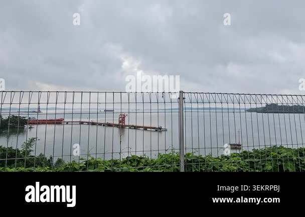 Balikpapan bay view from Balang island bridge.Fence bars frame a ...
