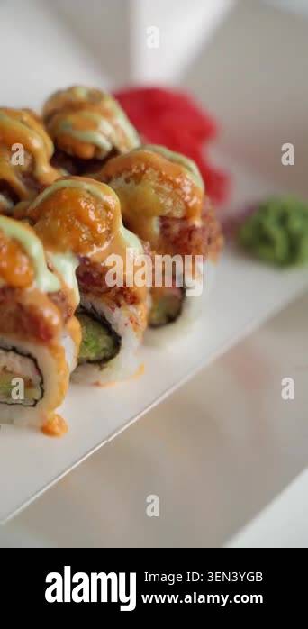 Close-up view of fresh Japanese sushi rolls with creamy sauce and fish ...