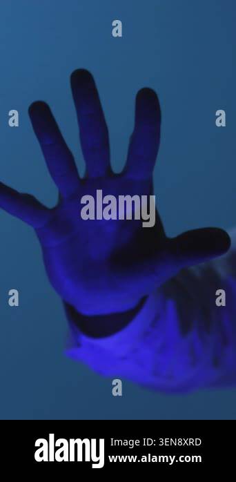 Forensic hand scan under cold blue lighting capturing fingerprint ...