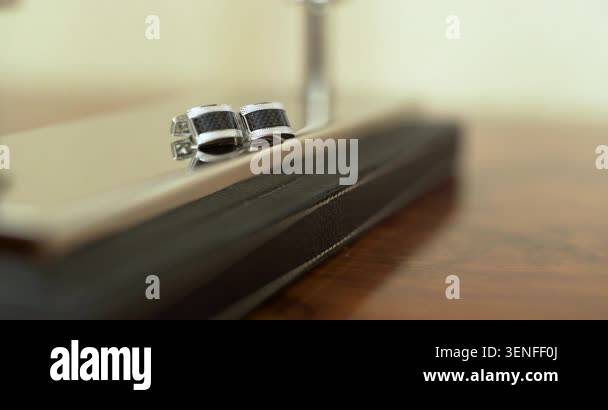 Close-up of two metallic zipper pulls on a black zippered case resting ...