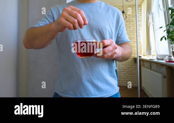 Man with hot brewed tea in a bag, medicinal red tea in a cup, slow ...