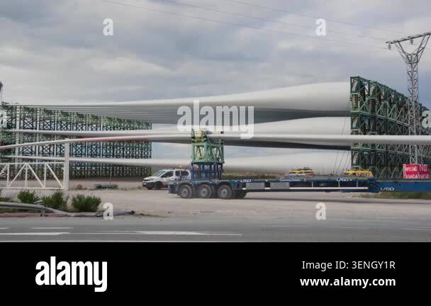 Large white wind turbine blades stacked on green steel storage racks at ...