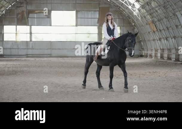 Young female equestrian riding a black horse Stock Video Footage - Alamy