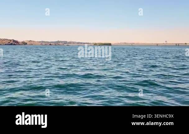 Calm blue water surface of the nile river gently waving under a clear ...