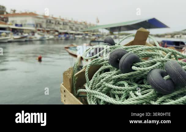 High resolution cinematic shot of traditional fishing nets stacked on a ...