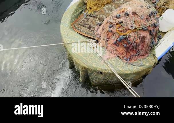 High resolution cinematic shot of traditional fishing nets stacked on a ...
