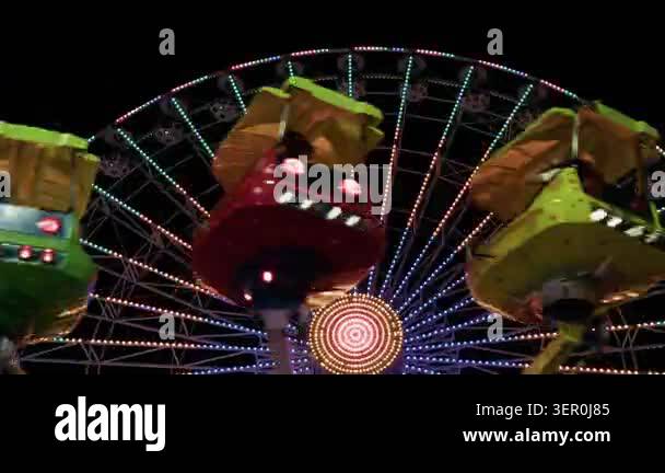 Dynamic shot of a fast spinning thrill ride at an amusement park at ...
