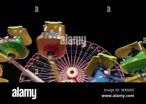Dynamic shot of a fast spinning thrill ride at an amusement park at ...