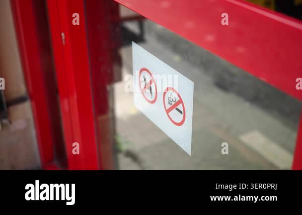 Signs on a red door clearly show no smoking and no entry rules Stock ...