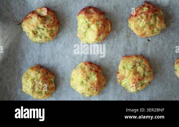 Close-up of golden, crispy baked zucchini tots freshly cooked and ...