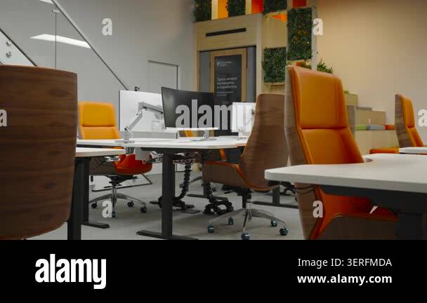 Bright open-plan office space with orange upholstered chairs, desks ...