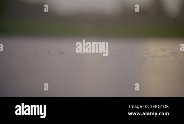 Moody abstract scene of raindrops sliding down wet glass with a soft ...