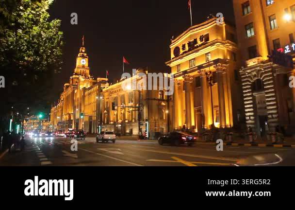 Nighttime street scene with cars driving past illuminated historic ...