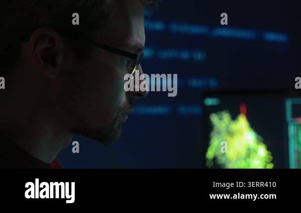 Close-up of a concentrated data scientist in glasses works focused on ...