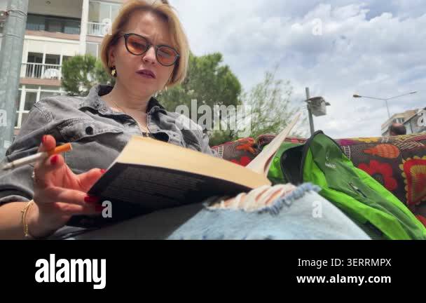 Blond Woman is Reading Book Outdoor Stock Video Footage - Alamy
