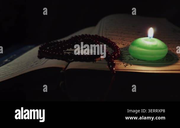 Holy Islam Muslim Book Quran And Rosary Prayer Beads In Candle Light holy-islam-muslim-book-quran-and-rosary-prayer-beads-in-candle-light