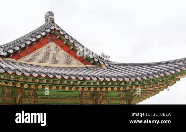 Asian visitors standing beneath decorative gable roof with painted ...