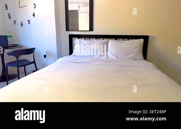 Simple clean white cheap hotel apartment room with bed table chairs and ...