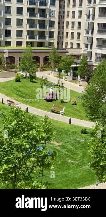 Visual Reference: Professional Groundskeepers Mowing Green Lawns With Lawn Mowers In A