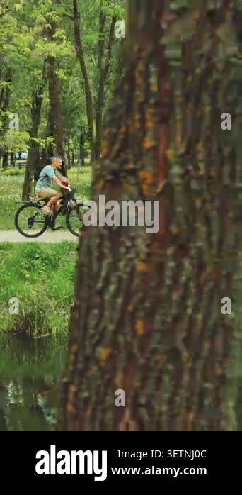 Happy family riding bicycles together along a park trail. Father ...