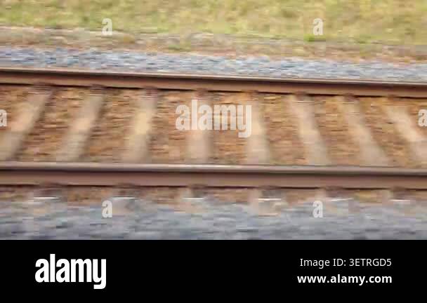 Train tracks viewed from a moving train, showing the continuous ...