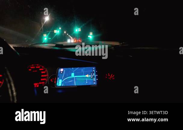 Car interior showing a smartphone with a gps navigation app guiding the ...