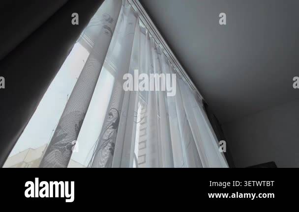 Low-angle view of delicate white organza curtains with a subtle pattern ...