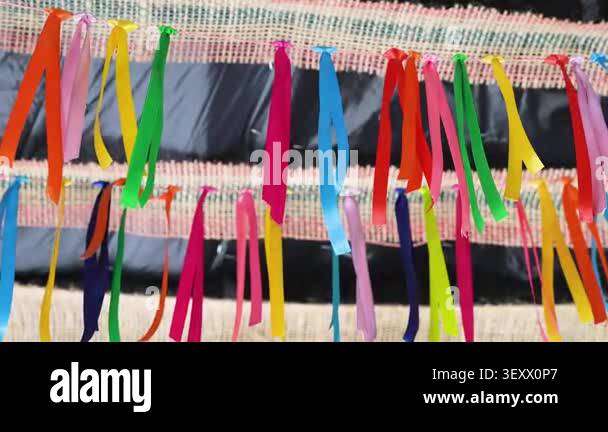 Vibrant multi-colored ribbons tied to a string garland for a festive ...