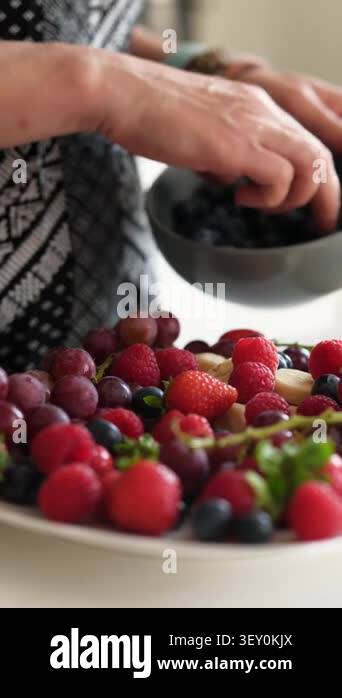 Woman Putting Grapes, Strawberries, Raspberries, Blueberries, And ...