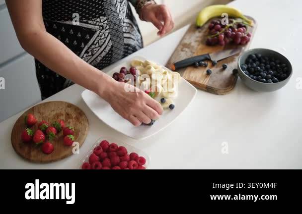 Woman Putting Grapes, Strawberries, Raspberries, Blueberries, And ...