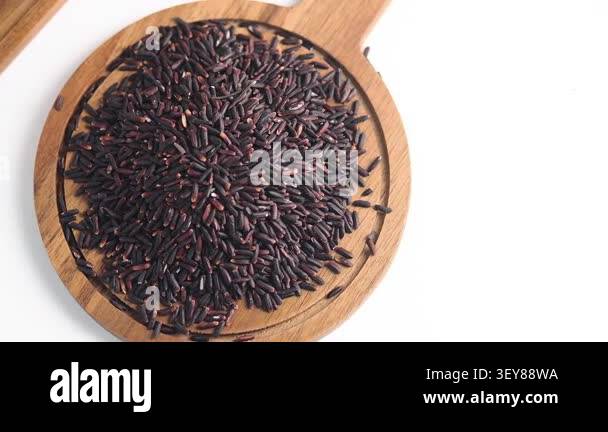 Black rice is shown on a wooden board for cooking meals Stock Video ...